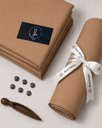 Premium men's unstitched suiting fabric in tan, neatly folded and rolled with branded ribbon, ideal for formal wear.